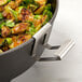 An American Metalcraft stainless steel lid holder holding a pan of brussels sprouts and onions.