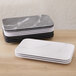 A stack of rectangular white and black American Metalcraft Mix & Matte rectangular platters.