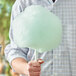 A man holding a large cotton candy made with Great Western green lime floss sugar.