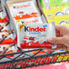 A person holding a package of KINDER chocolate bars.