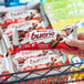 A hand holding a KINDER® Bueno hazelnut milk chocolate bar