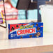 A blue box of Buncha Crunch Milk Chocolate candy on a table.