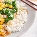 A plate of Royal Jasmine white rice with vegetables and chopsticks.