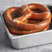 Two Ditsch Authentic German soft pretzels in a metal pan.