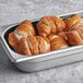 A metal tray of Ditsch Authentic German soft pretzel slider buns.