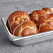 A metal tray with three Ditsch Authentic German Sliced Soft Pretzel Buns in it.