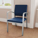 A Lesro Newport Patriot blue vinyl guest chair with silver metal arms.