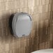 A Lavex Pro titanium commercial toilet paper dispenser on a white wall.