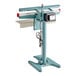 A teal-colored, foot-operated impulse heat bag sealer with a timer and a sturdy base.
