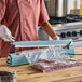 A 20-inch impulse heat bag sealer with a timer being used to seal a plastic bag filled with sprinkles.
