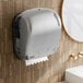 A Lavex Pro titanium paper towel dispenser on a wall above a sink.