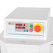 A white machine with red buttons and a red dial.