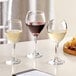 Acopa Bouquet wine glasses on a table with a glass of white wine and a glass of red wine.