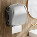 A Lavex Pro titanium automatic paper towel dispenser on a wall.