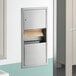 A Lavex stainless steel paper towel dispenser with waste receptacle on a wall.