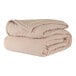 A stack of beige Berkshire Hospitality CozyCare fitted coverlets.