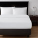 A bed made with a Berkshire Hospitality SuiteDream white duvet cover and pillows.