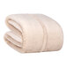 A folded beige Berkshire Hospitality Serasoft+ polyester blanket.