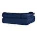 A stack of folded navy blue Berkshire Hospitality Microfleece blankets on a white surface.