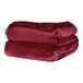 A stack of red Berkshire Hospitality VelvetLoft throw blankets.
