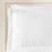 A white standard/queen size pillow sham with a quilted botanical leaf pattern.