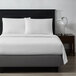 A white bed made with Berkshire Hospitality ecofiber white Derby top sheets.