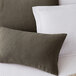 A close up of a Berkshire Hospitality diamond teak throw pillow on a white bed.