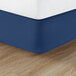 A blue Berkshire Hospitality Diamond Box Spring Cover on a mattress with white sheets.