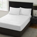 A bed with a Berkshire Hospitality quilted mattress pad with white sheets.