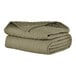 A stack of Berkshire Hospitality CozyCare Designs moss green bedspreads.