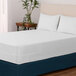 A white bed with a Berkshire Hospitality Protextile Full XL Size mattress encasement.