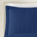 A blue Berkshire Hospitality pillow sham with a white botanical leaf border.