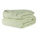 A stack of Berkshire Hospitality CozyCare twin size fitted coverlets in spa green.