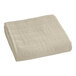 A close-up of a sand colored Berkshire Hospitality quilted bedspread with a botanical leaf pattern.