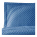 A close-up of a Berkshire Hospitality blue quilted pillow sham with a diamond pattern.