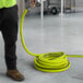 A person in a yellow shirt holding a Regency hose.