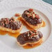 A plate of three pastries with chocolate and nuts drizzled with Ghirardelli Caramel Flavoring Sauce.