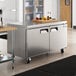 An Avantco undercounter freezer in a stainless steel kitchen with a large counter top.