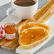 A piece of bread with Bonne Maman Apricot Preserves on it next to a cup of coffee.