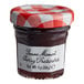 A Bonne Maman mini jar of cherry preserves with a white label and red and white checkered lid.