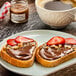 A piece of bread with Bonne Maman Hazelnut Chocolate Spread and strawberries on a white plate.