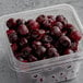 A plastic container of IQF Pitted Dark Sweet Cherries.