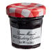 A Bonne Maman mini jar of wild blueberry preserves with a white label and red and white checkered lid.