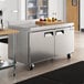 An Avantco stainless steel worktop freezer on a counter in a large professional kitchen.