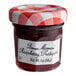 A Bonne Maman mini jar of raspberry preserves with a white label and a red lid.