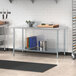 A Steelton galvanized steel undershelf on a stainless steel work table.