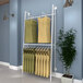 A white Econoco wall-mount A-frame retail clothing rack with clothes hanging on it.