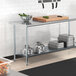 A Steelton adjustable galvanized steel undershelf on a stainless steel work table.