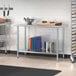A galvanized steel undershelf on a Steelton work table in a professional kitchen with different colored cutting boards.