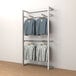 An Econoco wall-mount retail display rack with shirts and grey and white sweatshirts hanging on it.